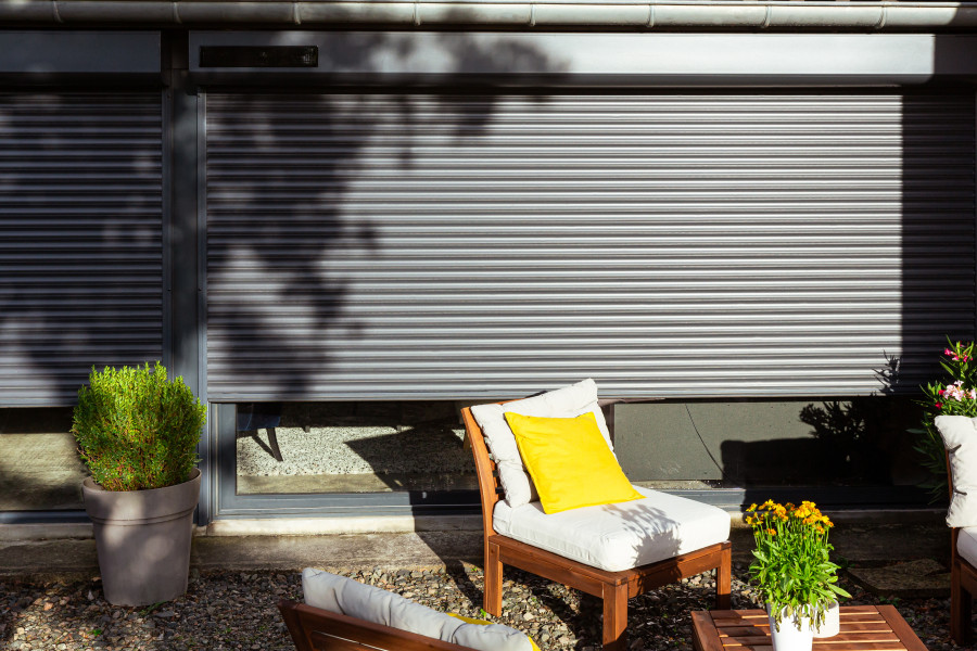 Volet roulant solaire motorisé vue gris anthracite avec terrasse juste devant la baie